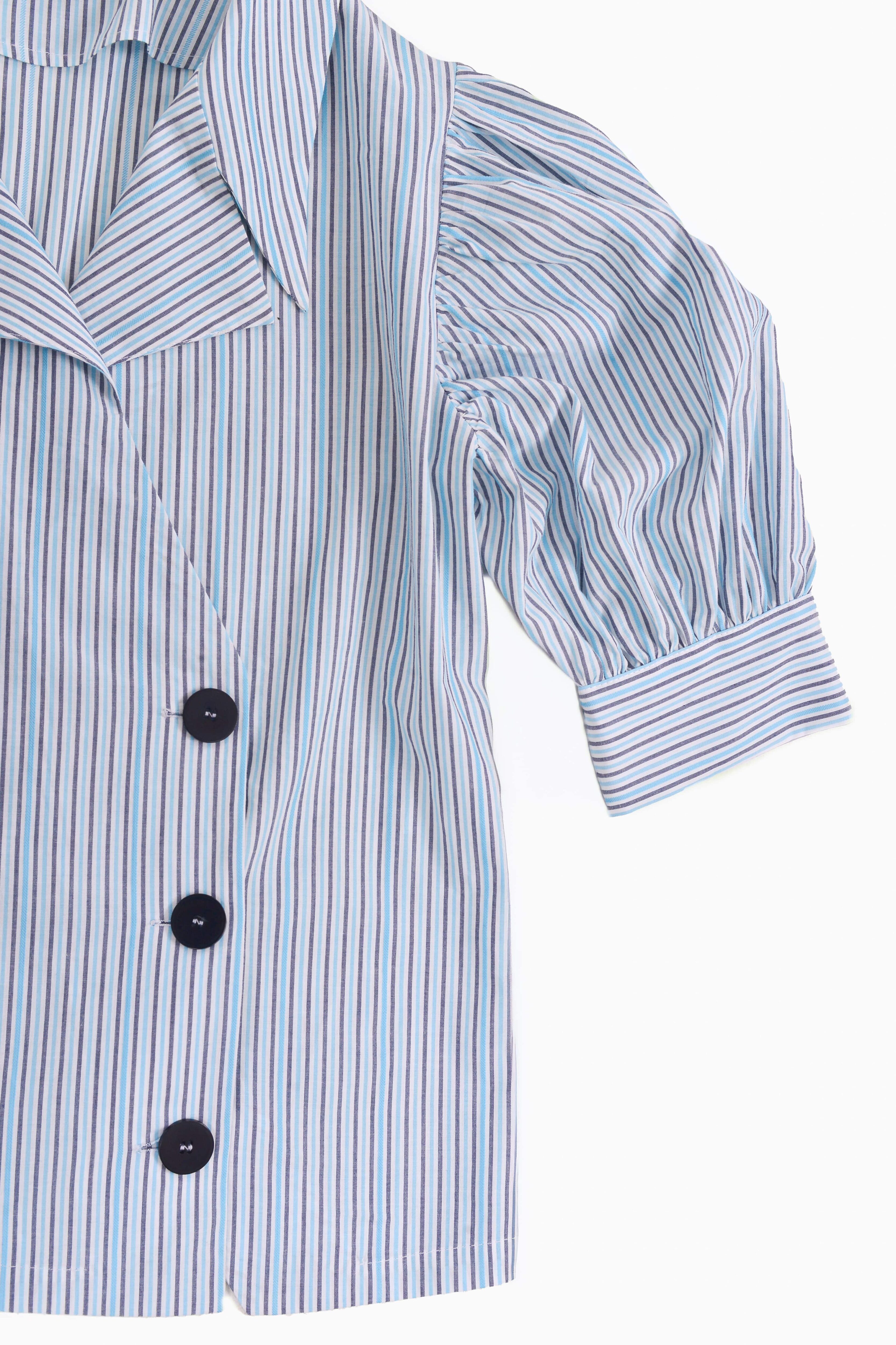 Détail de la chemise Gangnam rayée bleue avec boutons noirs et manches bouffantes – Collection ECHOES OF S(E)OUL & BEYOND – Maison Kumawo