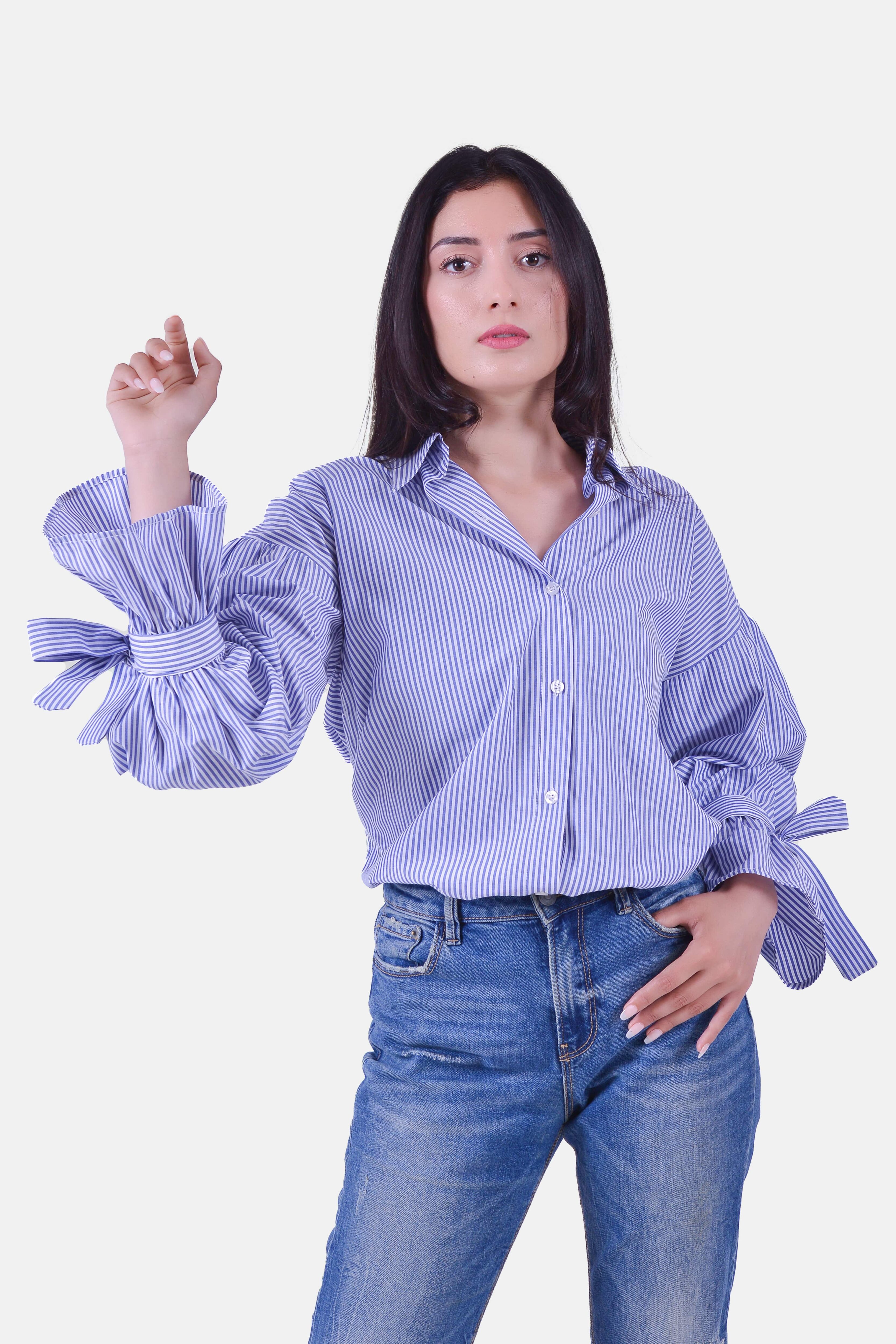 Femme portant la chemise rayée bleue manches longues nouées, pose élégante – Modèle Busan – Collection ECHOES OF S(E)OUL & BEYOND – Maison Kumawo