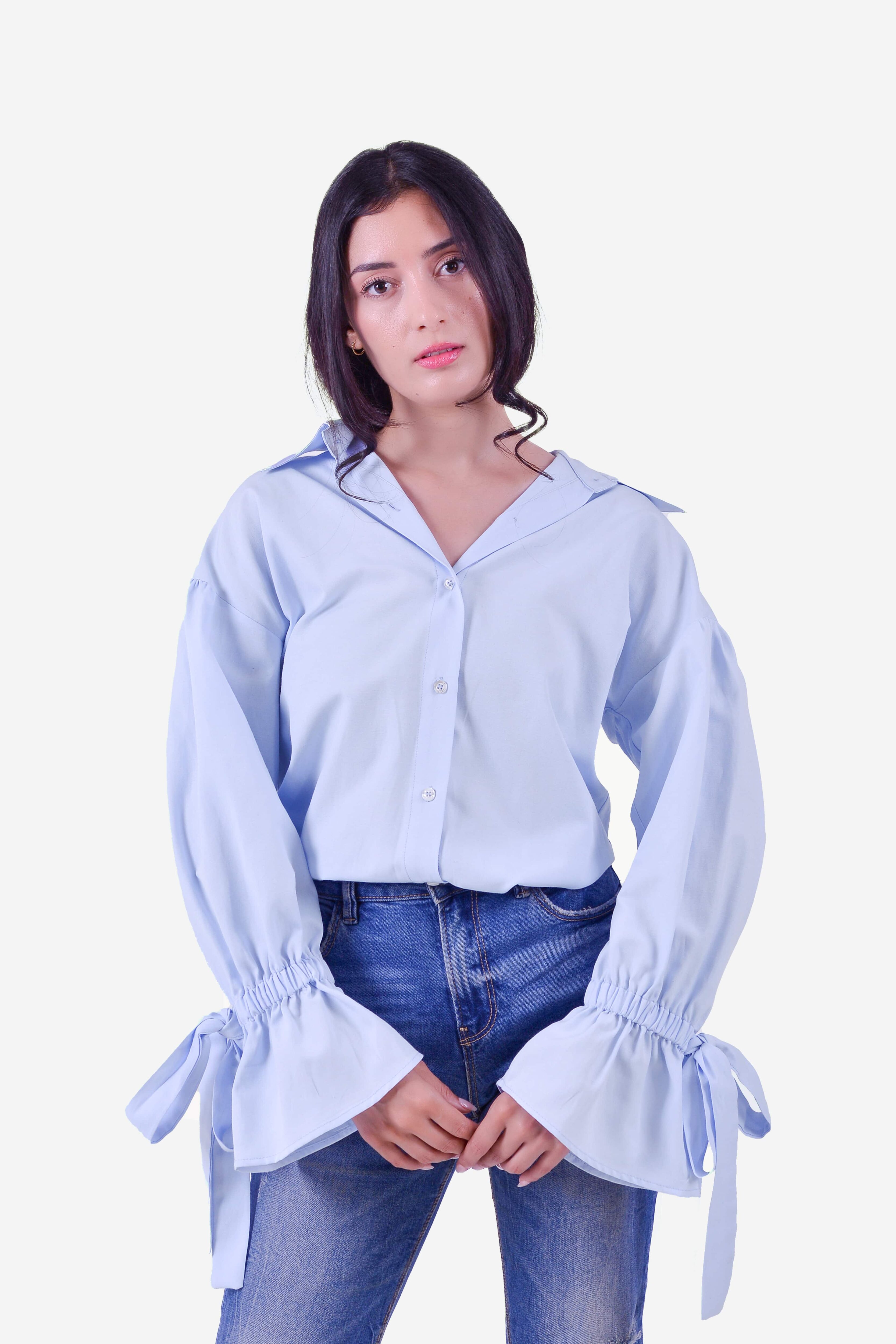 Femme portant la chemise bleu ciel à manches longues nouées au poignet – Modèle Busan – Collection ECHOES OF S(E)OUL & BEYOND – Maison Kumawo