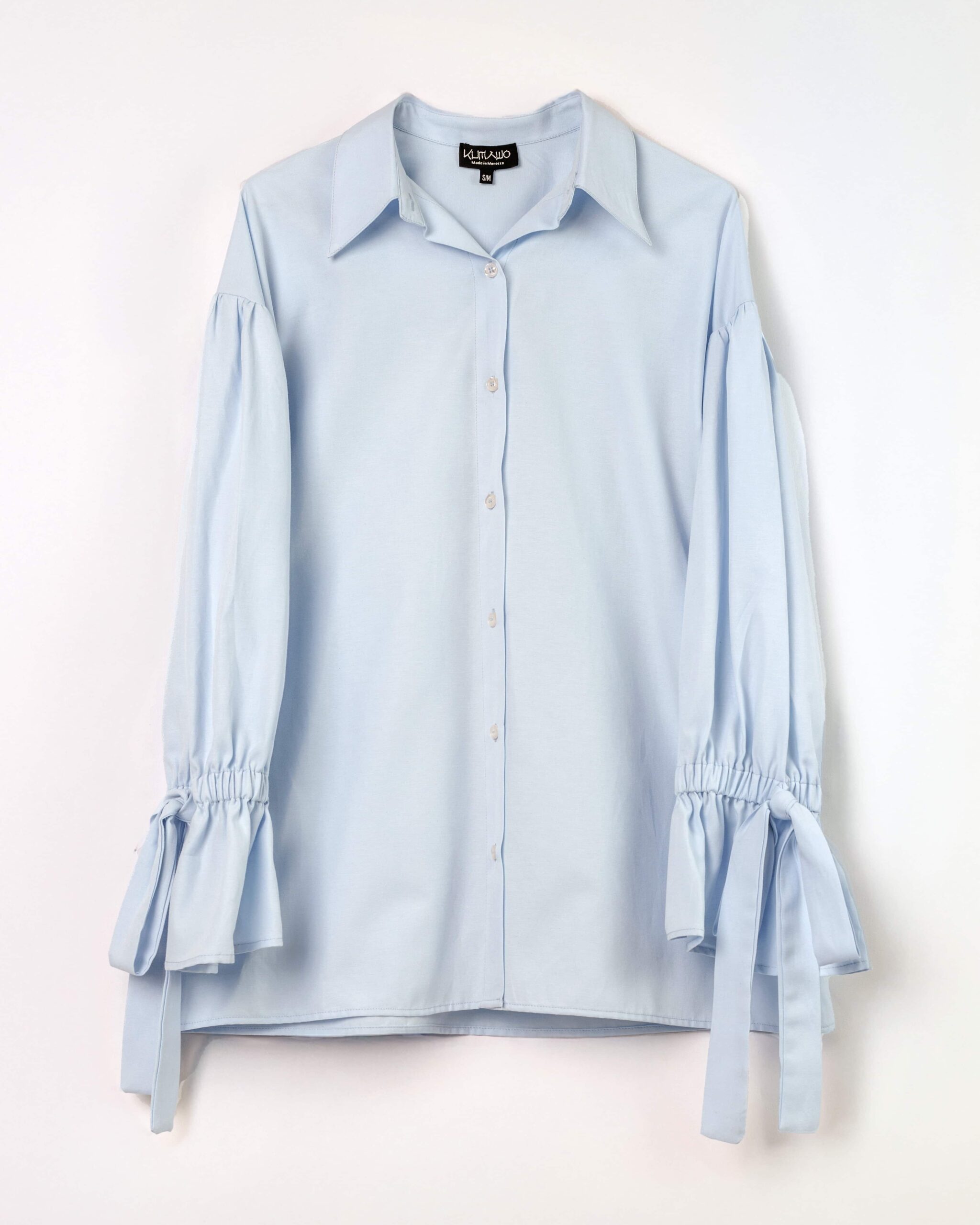 Vue avant de la chemise femme bleu ciel à manches longues nouées au poignet – Modèle Busan – Collection ECHOES OF S(E)OUL & BEYOND – Maison Kumawo